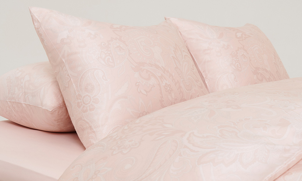 Bäddad säng i glansigt paisleymönster, rosa